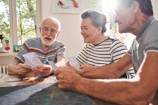 Retirement people sitting at the table at the living room and watching at the old photos