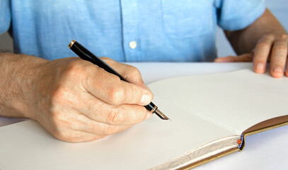 Hand with pen and notebook about to write.