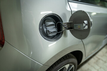 Open fuel cap of a electric car which is ready to get recharged with green power eco electricity.