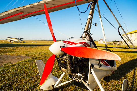 Close up of propellerof motor hang glider standing on green grass at aerodrome, bright summer day