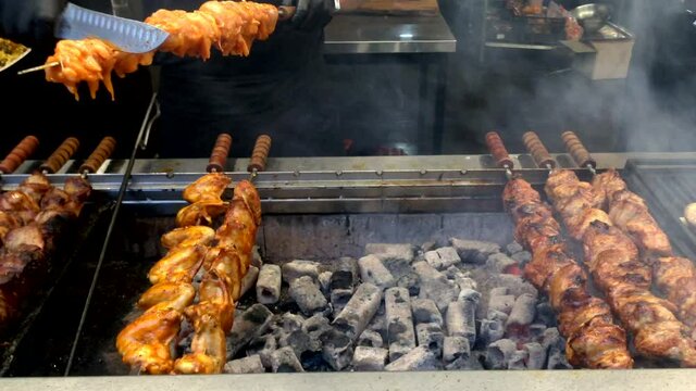 Rotating shish kebabs or shashlik cooking on coals