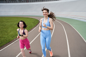 Obraz premium Midget woman running on the stadium with her best friend