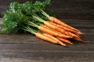 Bunch of fresh carrots on wooden table, selective focus, with copy space.