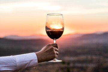 Copa de vino tras el sol en la montaña