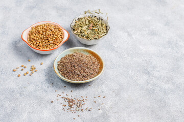 Coriander dry seeds in a wooden spoon.