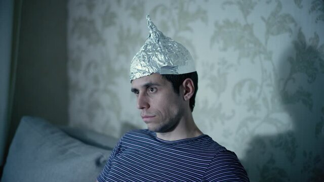 Strange man in a tin foil hat watching tv
