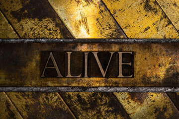 Alive text on vintage textured grunge copper and gold background