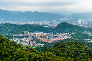 Fototapeta na wymiar Overlooking the urban architectural landscape of the Neihu and Nangang in Taipei, Taiwan, surrounded by green forests and mountains.