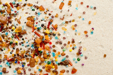 Stars falling. amber and beads on white sand background.