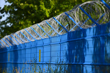 High strength, irresistible barbed wire fence made of sharp razor blades. Sharp gray steel in the...