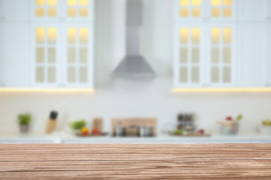 Empty wooden table and blurred view of stylish kitchen interior. Mockup for design