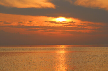 Naklejka na ściany i meble Evening sun over the tropical sea with waves. Nature background