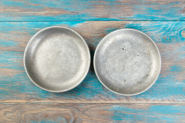 Old metal plates for scales on wooden background.