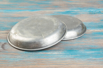 Old metal plates for scales on wooden background.
