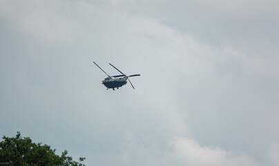 Fototapeta na wymiar RAF Boeing Chinook UH-1 helicopter flying low in a cloudy blue grey and white summer sky