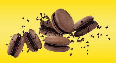 Sweet delicious macarons flying on yellow background