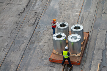 Foreman and Chief Officer checking steel cargo galvanized coils before loading.