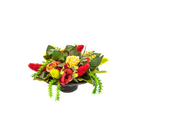 Obraz premium Artificial blooming flowers and grass in a basket isolated on white with place for text.