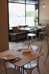 cozy place. a table inside an Italian restaurant with serving plates, knives and forks