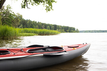 Boat , canoe-kayak on water , lake on background of green summer forest. Concept of sport leisure activities, recreation, entertainment in nature. Copy space for text