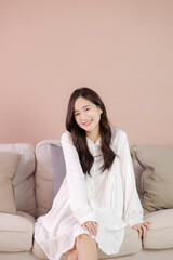 At cozy living room happy woman sitting on sofa. female enjoy lazy weekend or vacation