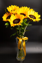 Fototapeta premium Bouquet of bright sunflowers against black background