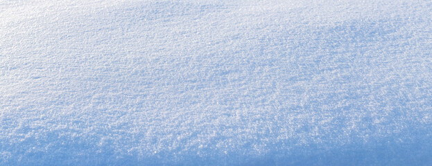 Snowy background, snowy surface with a clearly expressed texture of snow in the morning sun