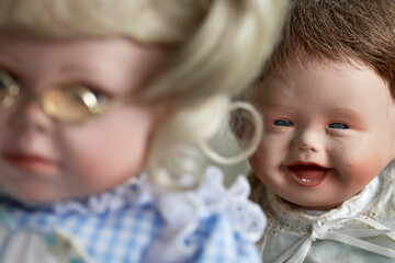 Vintage baby doll laughing at female doll with glasses