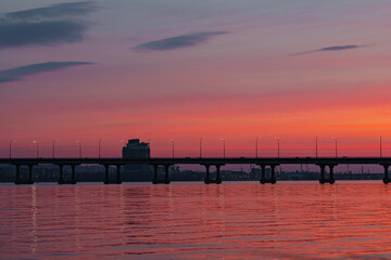 Obraz premium colorful sunset late at night by the water on the road