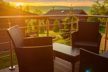 Wicker furniture on terrace house. Wicker chairs and table on a sunset background. Concept - sale...