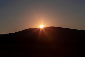 Fototapeta na wymiar sunrise over the top of a mountain