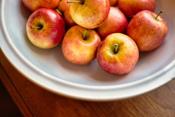 White bowl with red apples