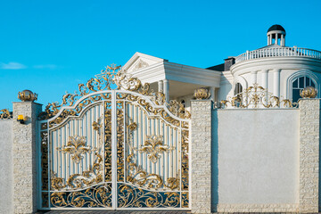 Chic gate with gold elements in the mansion. Beautiful handmade gate in white and gold color.