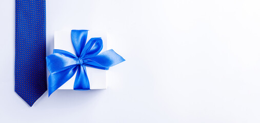 Gift father day. Blue bowtie or tie, white box with bow ribbon on light background. Happy loving family and Fathers Day concept.