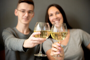 a young couple tasting white wine,close up of hands holding glass