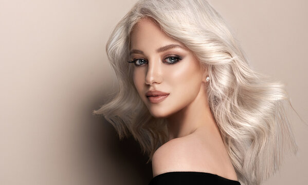 Beautiful girl with hair coloring in ultra blond. Stylish hairstyle done in a beauty salon. Fashion, cosmetics and makeup