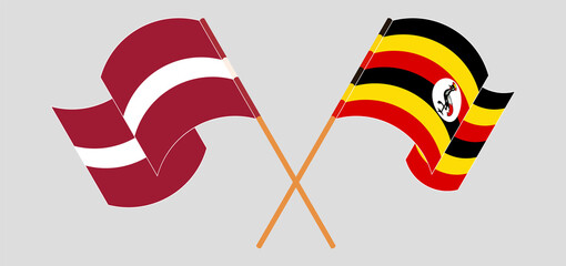Crossed and waving flags of Latvia and Uganda