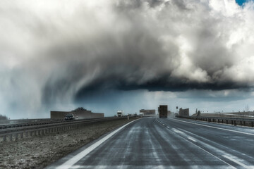 Dramatic view of a shelf cloud over a highway, horizontal cloud formation, panorama view.