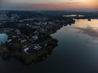 Scenic aerial sunrise time on wide calm river with mirror surface. Early morning, dawn in Kharkiv Zhuravlivskyy Hidropark from sky. Drone photography