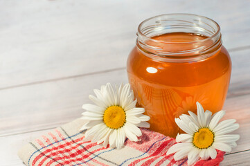 Obraz na płótnie Canvas fresh honey in a transparent jar on a wooden background. High quality photo
