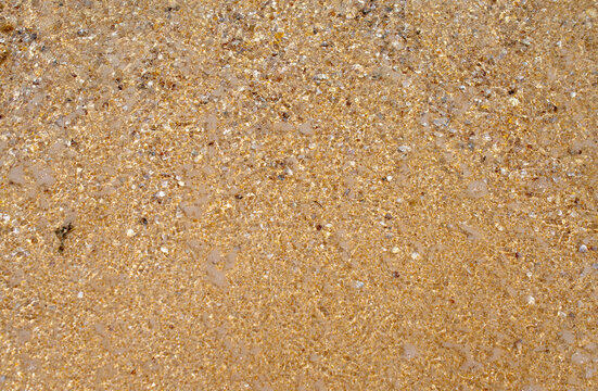 Sandy seashore with golden sand. Beautiful summer background. Design of a template, photo wallpapers, covers, screensavers.