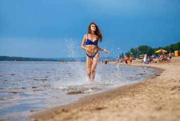 Fototapeta na wymiar Portrait of a young beautiful brunette woman posing in blue bikini