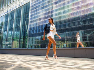 Fototapeta na wymiar Portrait of a young beautiful brunette woman walking in summer street