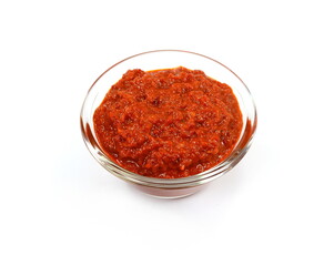 Ajvar in a bowl isolated on white- traditional macedonian serbian dish made from red bell peppers, eggplant and garlic, lutenitza, popular in Balkans. Homemade tomato sauce for pasta.