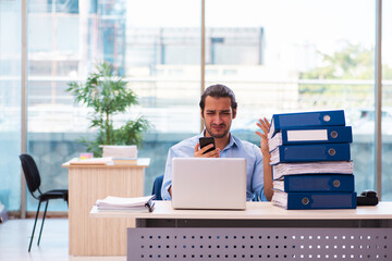 Young male employee and too much work in the office