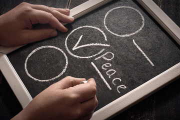Handwriting choose peace on a chalkboard close up.