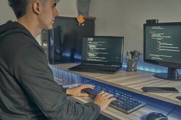 Programador escribiendo un código informático en su oficina por la noche