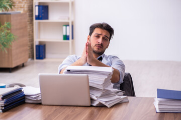 Young businessman employee unhappy with excessive work in the office