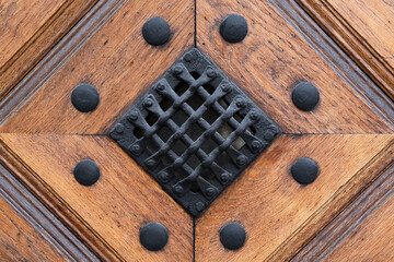 Detail of Old door. Iron Mesh on the wooden door with metallic rivets on it. Antique Decor