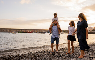 family walking on the beach at sunset one day of their vacation